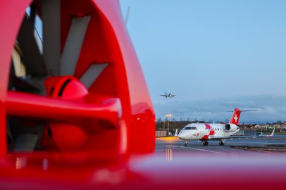 Ein Ambulanzjet hinter dem Fenestron eines Rettungshelikopters