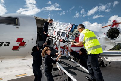 Der Transportinkubator wird über die Rampe in den Ambulanzjet geladen.
